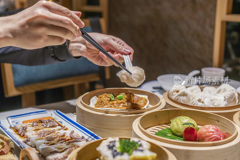 人们用筷子和勺子吃广东dum sum虾饺